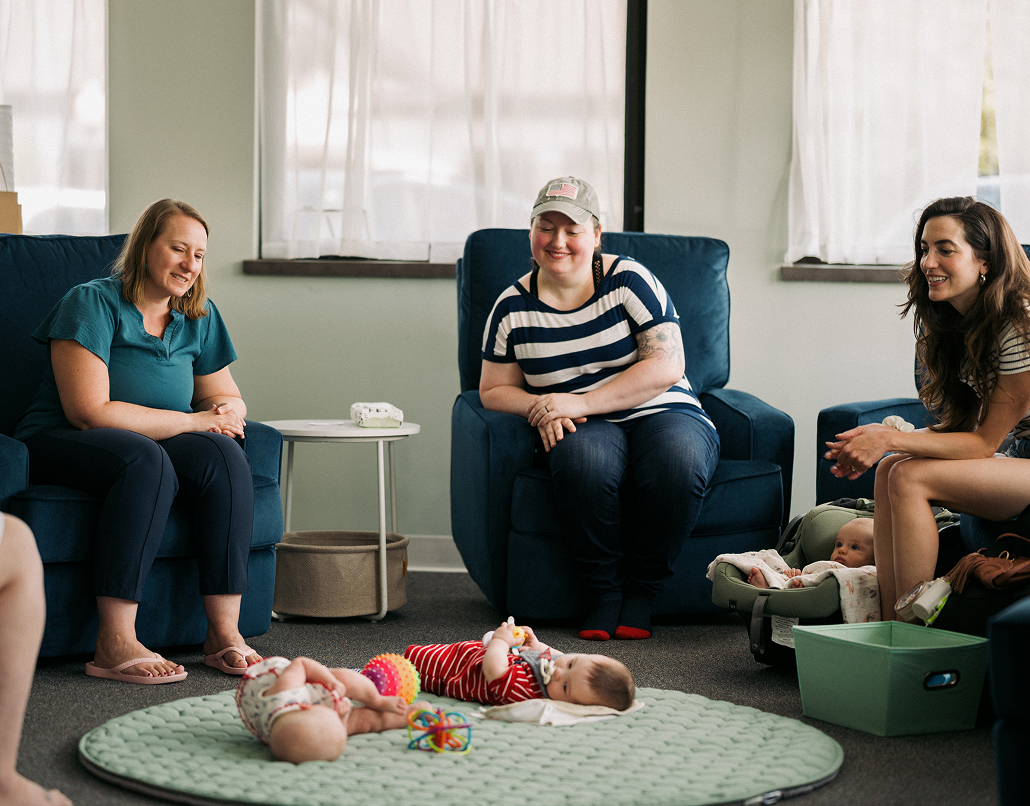 New moms and babies sitting together in a support circle